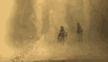 two soldiers are walking through a cloud of dust in a desert .