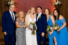 a bride and groom pose for a picture with their parents and bridesmaids