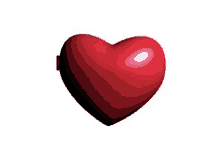 a red heart is floating in the air on a white surface .