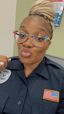 a police officer wearing glasses and a patch with an american flag on it