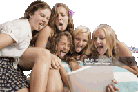 a group of girls sticking their tongues out and looking at a tablet