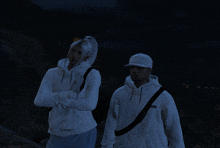 a man and a woman standing next to each other wearing white sweatshirts