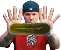 a man wearing a red shirt and a blue hat is holding a pickle in front of his hands