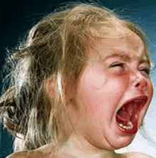 a young girl is crying with her mouth wide open .