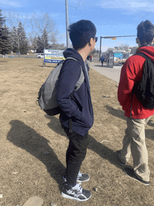 a boy wearing a backpack stands in front of a sign that says " the simpson 's place "