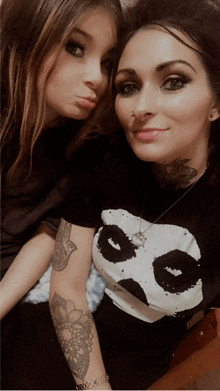 two women posing for a picture with one wearing a panda t-shirt