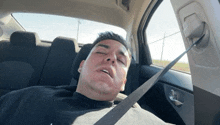 a man is sleeping in a car with his eyes closed