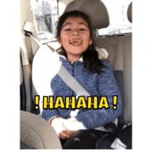 a little girl is sitting in the back seat of a car with a seat belt around her neck .