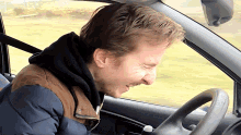 a man making a funny face while sitting in a car