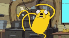 a yellow cartoon dog is dancing in a kitchen .