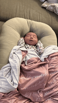 a baby is wrapped in a pink blanket with the name jasmine written on it