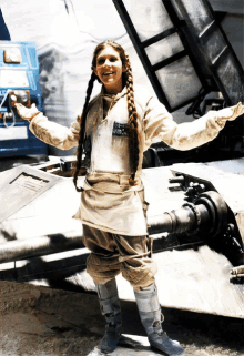 a woman with a braided hair stands in front of a vehicle