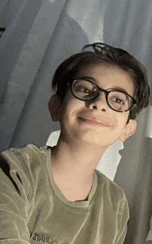 a young boy wearing glasses and a shirt that says ' ayahla ' on the front