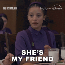 a woman in a purple shirt is sitting at a table with a glass of milk and says she 's my friend