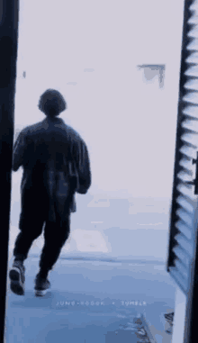 a person is walking through a doorway looking out .