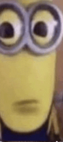 a close up of a minion wearing glasses and making a face .