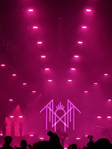 a group of people are standing on a stage with pink lights and a logo that says tht