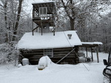 a snowy cabin with a tower on the top of it