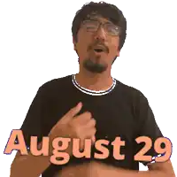 a man wearing glasses and a black shirt with the date august 29 on it