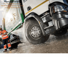 a man is washing a garbage truck with a royale truck service logo