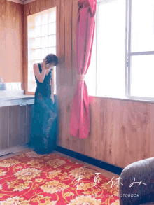 a woman in a blue dress stands in front of a window with the words photobook on the bottom right