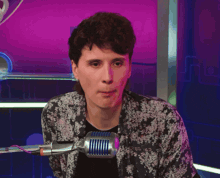 a person sitting in front of a microphone with the number 9 on the wall behind them
