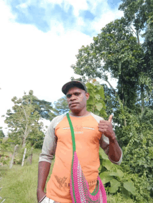 a man wearing a shirt that says ' anza ' on it giving a thumbs up