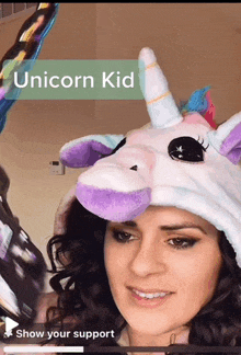 a woman wearing a unicorn hat with the words " unicorn kid " on it