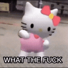 a hello kitty doll is standing on a street with the words what the fuck below it