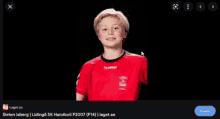 a picture of a boy in a red hummel shirt on a black background