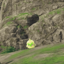 a yellow bird with green eyes is standing on a grassy hill .