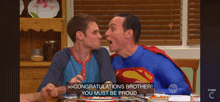 two men in superman costumes congratulate each other