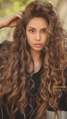 a woman with long curly hair is wearing a black shirt and a photolab logo