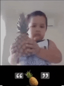 a young boy is holding a pineapple in his hands in a video .