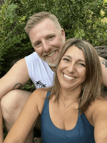 a man and a woman are posing for a picture and the man has a tattoo of a palm tree on his arm