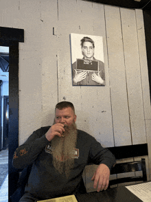 a man wearing a harley davidson shirt sits at a table