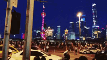 a crowd of people are gathered in front of a city skyline at night with a sign that says ' a ' on it