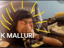 a boy with red eyes is sitting in a chair with the words " k malluri " written above him