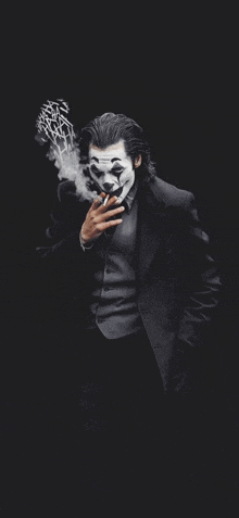 the joker is smoking a cigarette on a black background