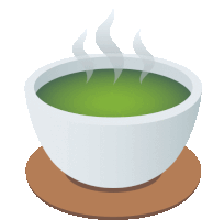 a white bowl filled with green liquid with steam coming out of it