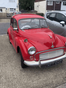 a red car with the license plate htt1040 is parked in a driveway