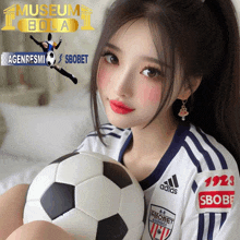 a girl holding a soccer ball in front of a museum bola banner