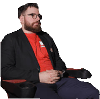 a man wearing glasses and a red shirt is sitting in a chair