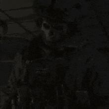 a skeleton is standing in the dark in a dark room with a gun .