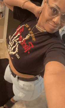 a woman taking a selfie wearing a black shirt that says " heavy metal " on it