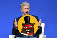 a man sitting in a chair holding a yellow circle with a cat in a top hat on it