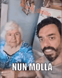 a man with a beard is posing for a picture with an elderly woman and says nun molla