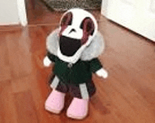 a stuffed animal is standing on a wooden floor wearing a green jacket and pink shoes .