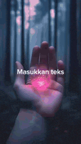 a hand holding a pink object with the words meng b masukkan teks