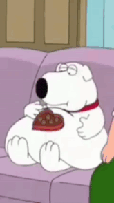 a cartoon character is sitting on a couch eating a heart shaped chocolate .